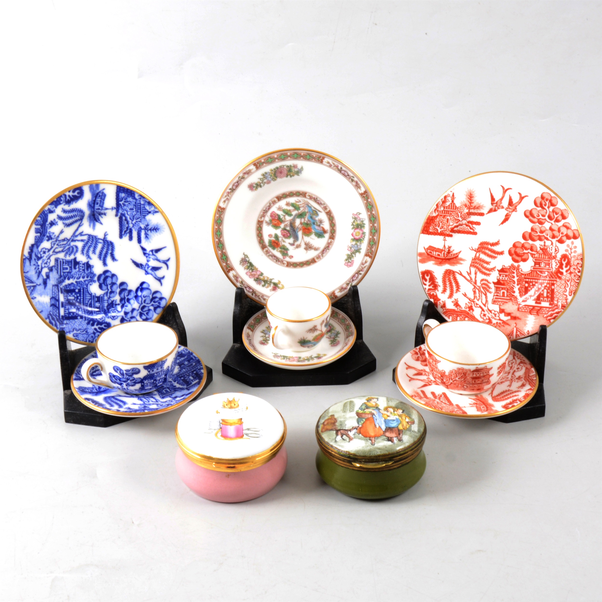 A collection of modern enamel pill boxes and miniature Wedgwood trios.