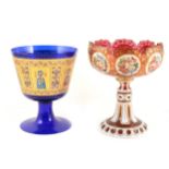 A Bohemian ruby glass pedestal dish overlaid in white and gilt with eight floral vignettes, and a