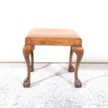 A walnut dressing table stool, with cabriole ball and claw feet, and a dressing table.