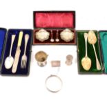 A pair of silver berry spoons, London 1834, a cased condiment set, scallop shaped on three feet by