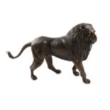 A bronze model of a standing lion.