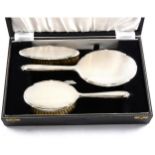 A cased silver backed dressing table set,