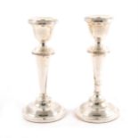 A pair of silver candlesticks with filled bases,