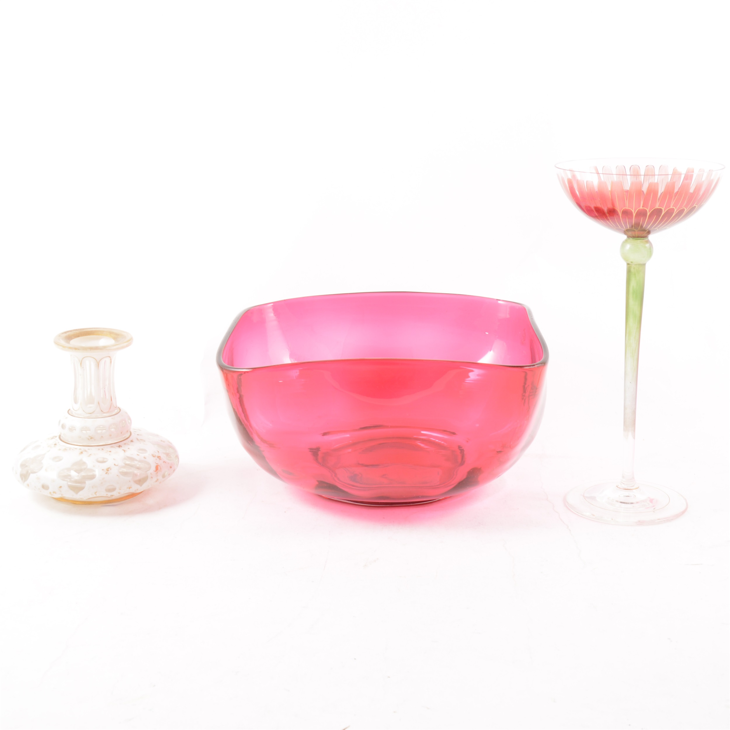 A cranberry glass dish, square with curved corners, a small white overlaid glass vase, faded gilded