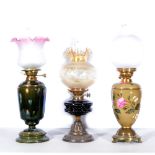 Three oil lamps, to include Hink's Duplex, orange shade with impressed floral design, black ceramic