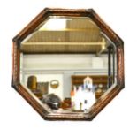 An octagonal copper framed mirror.