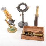 A lacquered brass student microscope, field microscope, and two telescopes