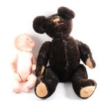 Old black teddy bear and a bisque head doll by Armand Marsielle