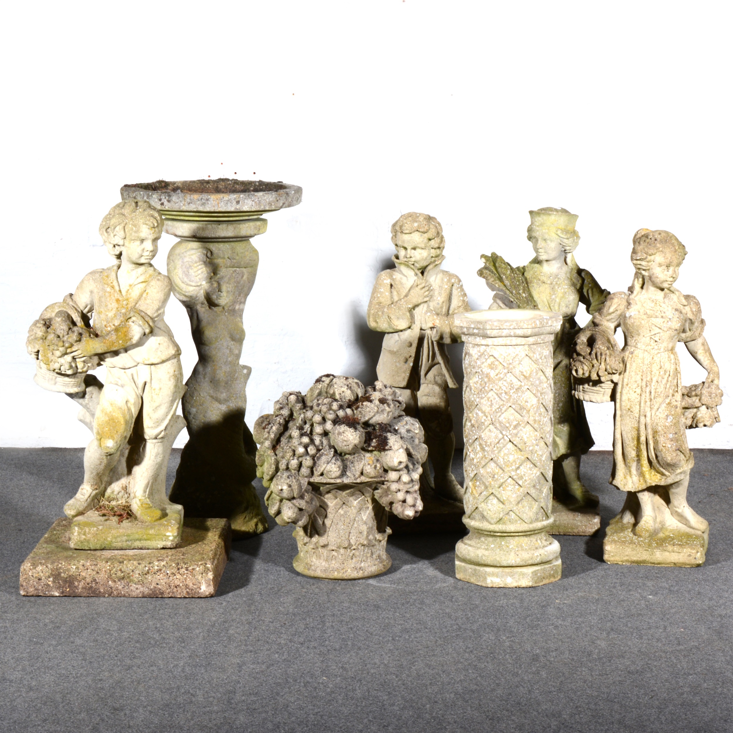 Four garden statues, a bird bath, and a decorative garden pedestal with fruiting urn.
