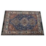 A Qashqai rug, three joined lozenge medallions on a blue ground, ...