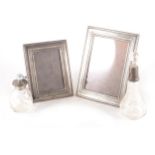 Two silver photograph frames, silver topped scent bottle and silver topped atomiser.