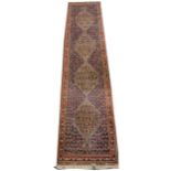 A Persian patterned runner, with four joined lozenge medallions ...