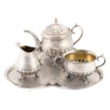 A white metal three piece teaset with tray.
