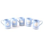 A collection of Wedgwood Blue Jasperware commemorative mugs, ...