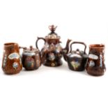 A collection of Measham pottery, including teapot and stand, small teapot, kettle and two milk jugs.