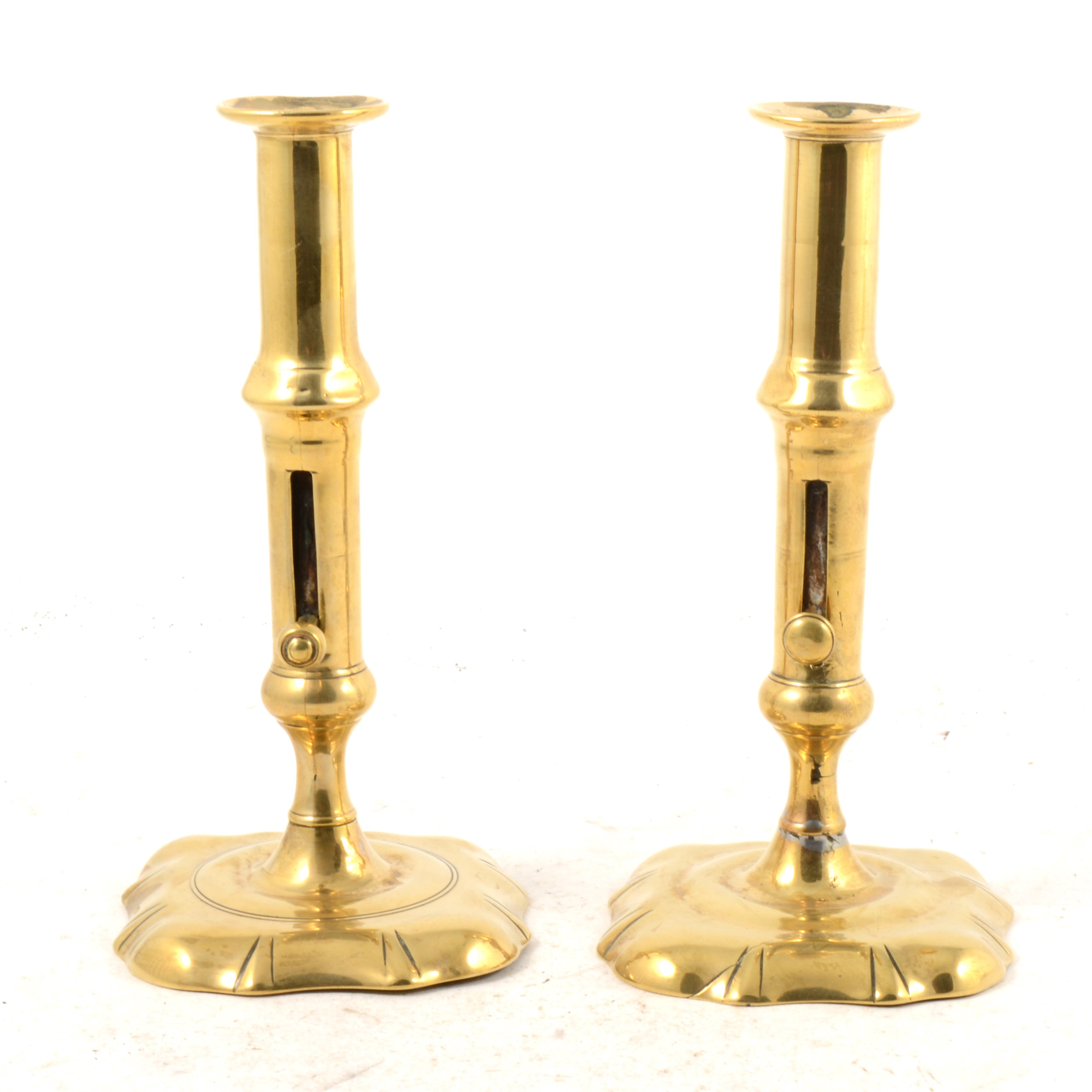 Pair of George III brass candlesticks with column retractors, shaped bases, 20cm.