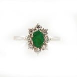 An emerald and diamond oval cluster ring.