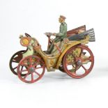 An early 20th Century tin-plate vintage motor car, with spoked wheels, driver and steering wheel,