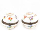A pair of Continental porcelain trinket boxes with metal mounts.