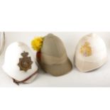 A Leicestershire Regiment tropical helmet and two other tropical helmets.