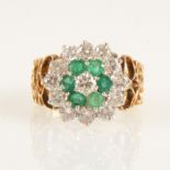 An emerald and diamond circular triple cluster ring,