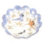 A Japanese porcelain shallow dish, decorated with cranes