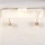 A pair of diamond solitaire earrings.