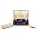 Two silver cigarette cases and a silver manicure set.