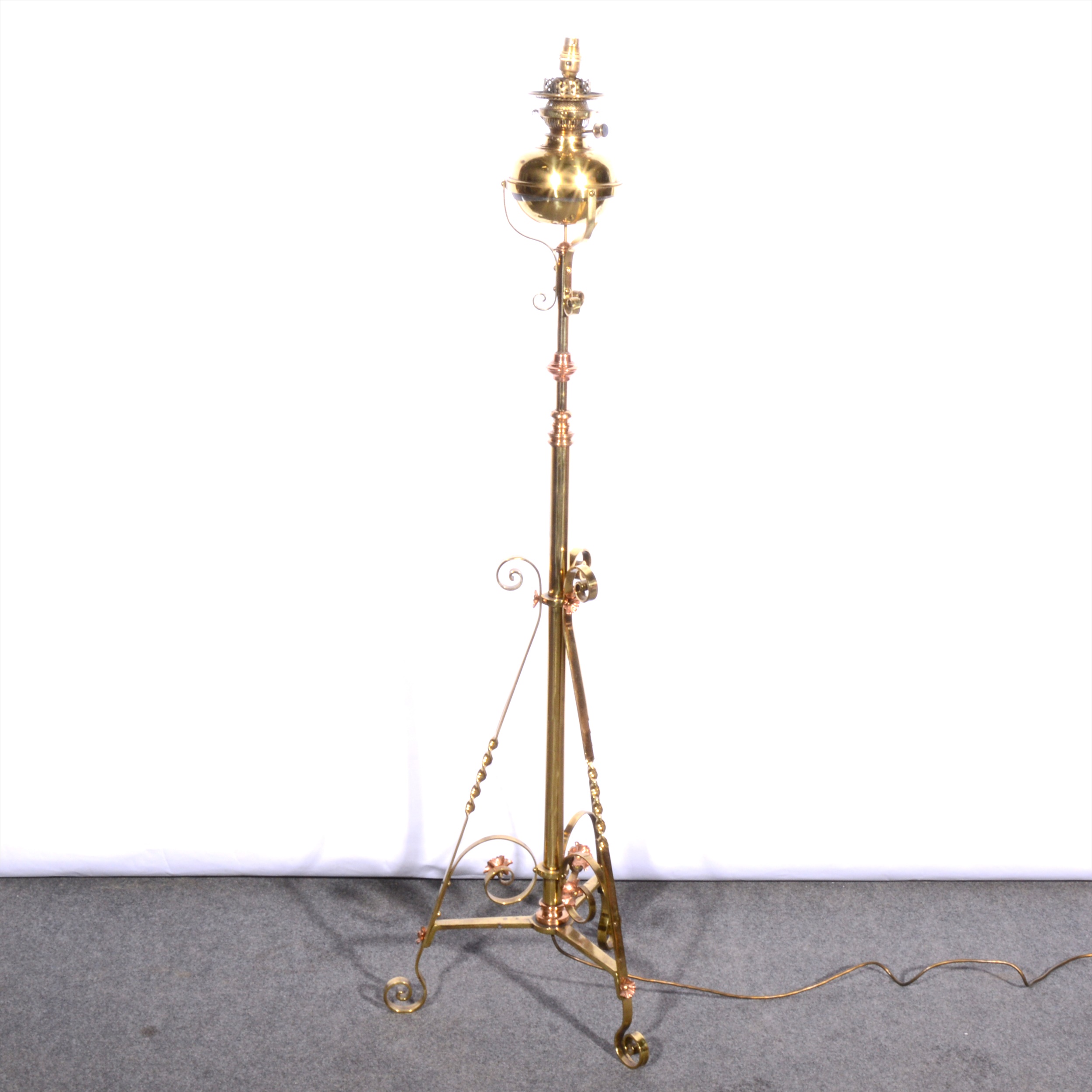 An English Art Nouveau lacquered brass and copper adjustable standard lamp, manner of Benson