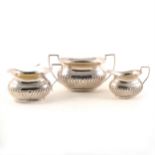 A silver sugar bowl, Mappin & Webb, Sheffield 1893, and two similar milk jugs.