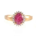 A ruby and diamond oval cluster ring.