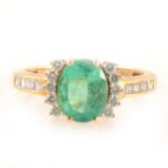 An emerald ring with diamonds to each side and to shoulders.