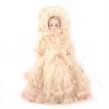 A bisque head doll, with kid leather body, in a lace outfit hand woven material made in