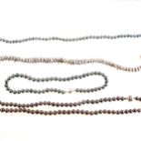 Four cultured pearl necklaces, greys, black and a natural colour simulated pearl necklace.