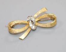 An 18ct gold and diamond set ribbon bow brooch, 33mm.