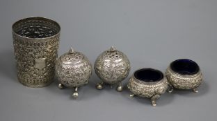An Indian repousse white metal beaker and a similar four piece condiment set.