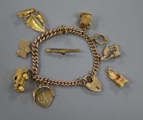 A 9ct gold charm bracelet hung with eight assorted charms, a tiepin and a coronation chair charm,