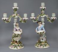 A pair of German three light table candelabra, modelled with a figure of a gallant and lady