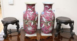 A pair of large 19th century Chinese pink ground 'dragon' vases with carved wood stands