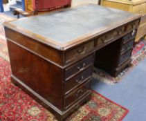 A Victorian mahogany pedestal desk, fitted nine small drawers, opposing panelled cupboards, the