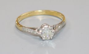 An 18ct gold and platinum set single stone diamond ring with diamond set shoulders, the central