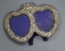 A late Victorian repousse silver mounted double heart shaped photograph frame, London, 1982, width