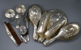 A George V repousse silver six piece dressing set, three silver topped toilet bottles, etc.