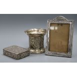 A late Victorian repousse silver bottle stand, a late Victorian silver box by William Comyns and a