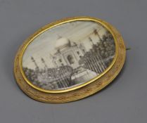 An Indian oval miniature on ivory painted with the Taj Mahal in a yellow metal mount, mount tests as