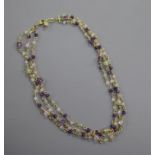 A modern 18ct gold and gem set triple strand necklace, set with amethyst, peridot etc, approx.