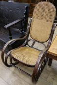 A stained beech bentwood rocking chai, with caned seat and back
