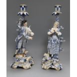 A pair of Meissen musical shepherd and shepherdess candlesticks, glazed in blue, white and gilt on
