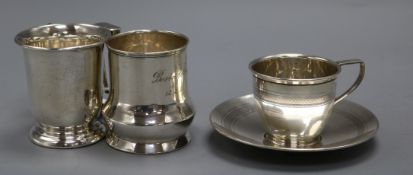 Two 20th century silver christening mugs and a George V silver cup and saucer, 10 oz.