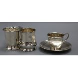 Two 20th century silver christening mugs and a George V silver cup and saucer, 10 oz.